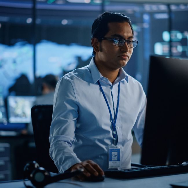 Professional It Technical Support Specialist And Software Developer Working On Computer In Monitoring Control Room With Digital Screens With Server Data, Blockchain Network And Surveillance Maps.