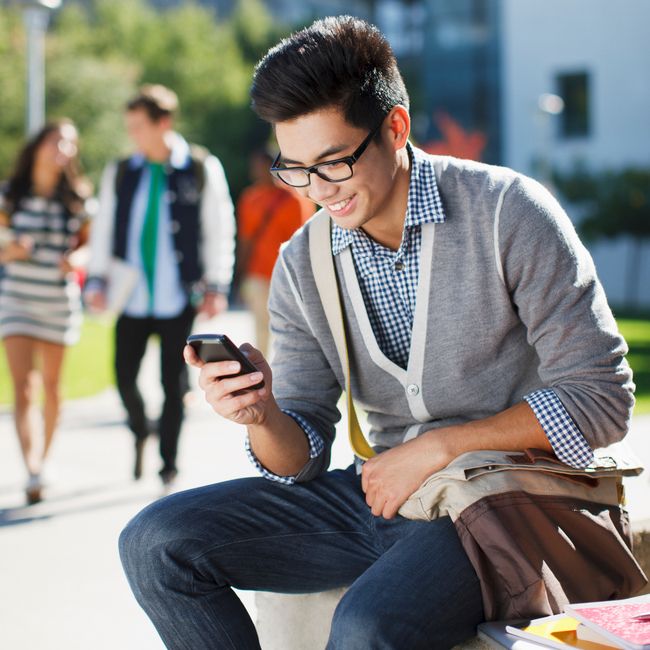 Smiling Student Using Cell Phone Outdoors